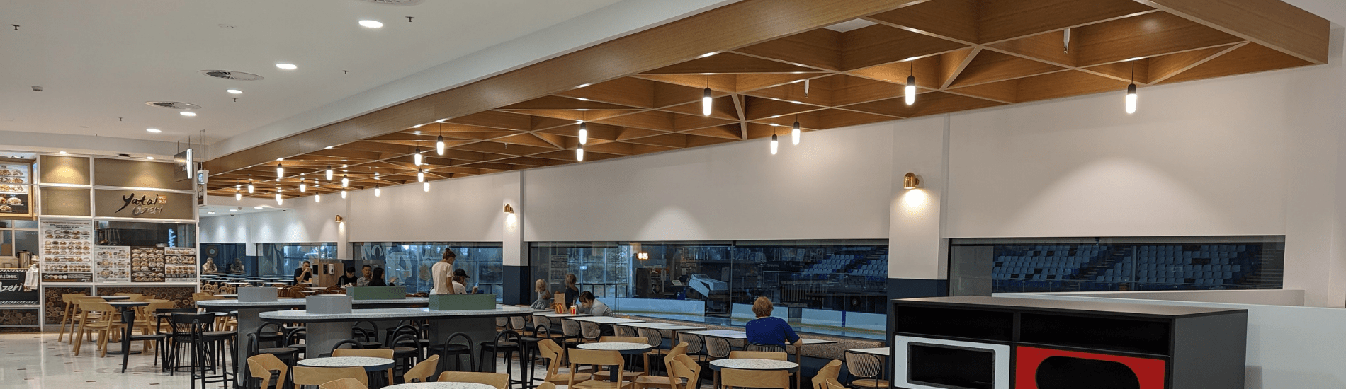 Eye-catching used of criss cross beams to define seating areas of a food court
