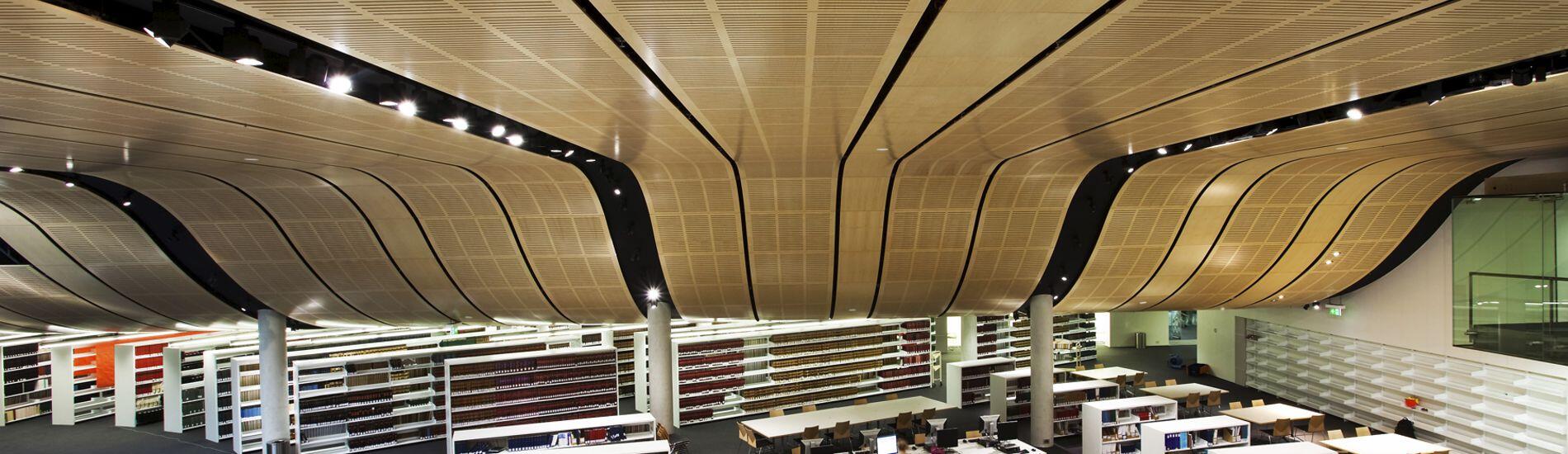 Sweeping curved SUPACOUSTIC slotted acoutic panels solve noice echo in large library space