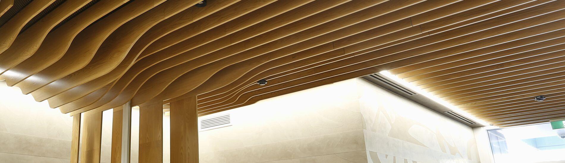 WAVE BLADES Backed With SUPACOUSTIC Acoustic Panels Form BCA Compliant Feature Ceiling in School Entry