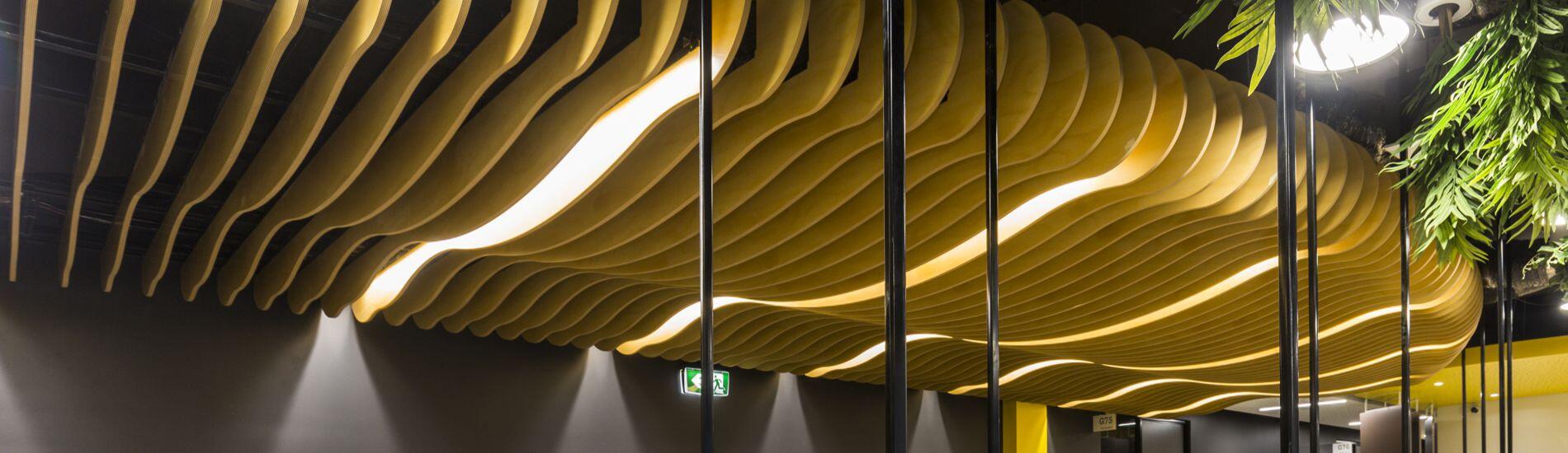 WAVE BLADES Ceiling Features and Decorative Screens Define Areas of Student Hub